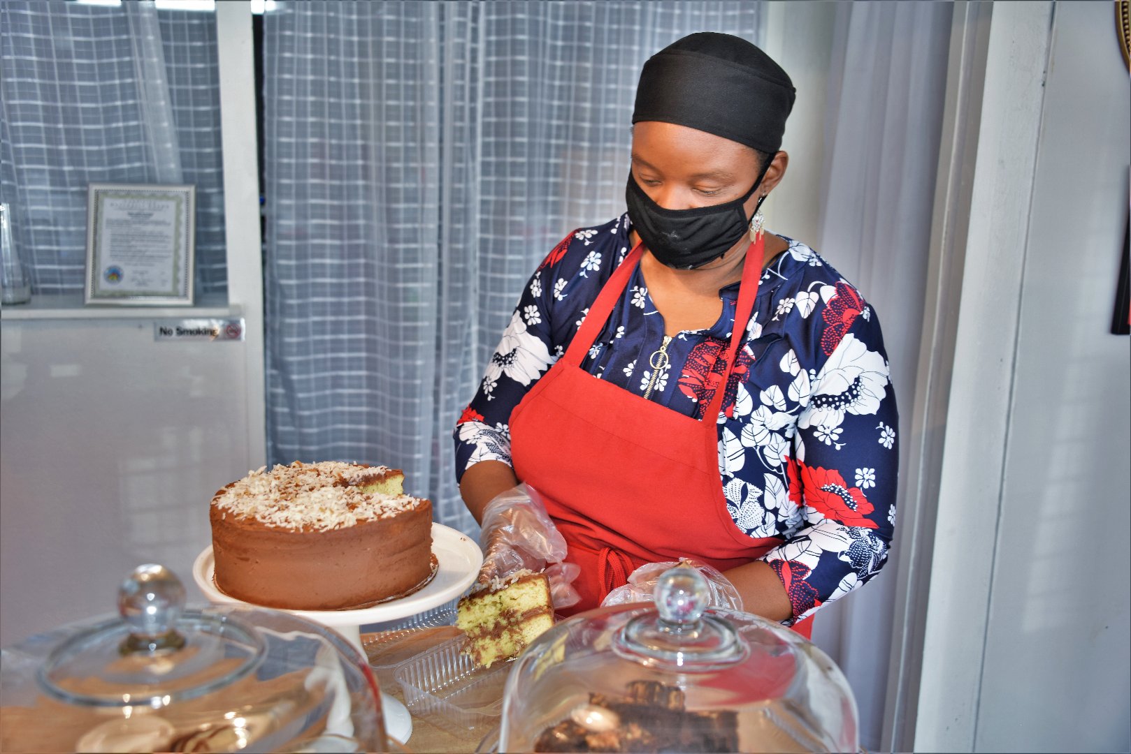 Dr. Hamidah Sharif, owner of Sweet Valley Bakery and Farmstand, cuts a slice of sugar-free cake for a customer.
