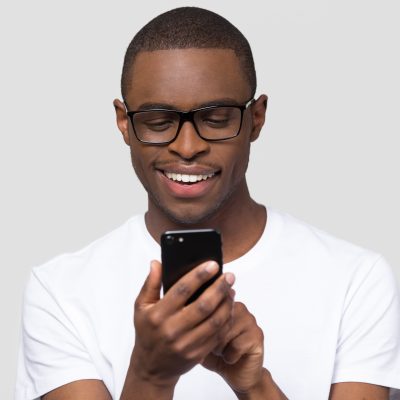 Young man smiling while looking at cell phone
