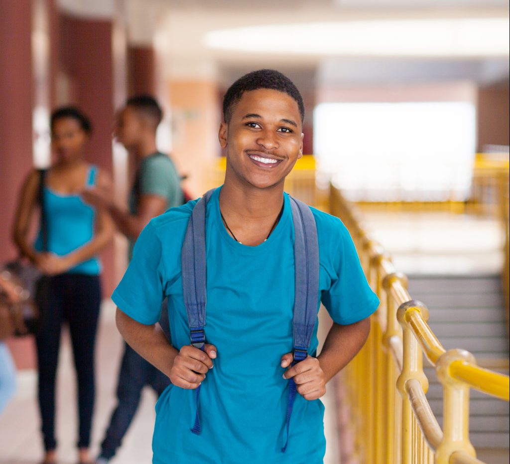 highschool student with backpack smiling at camera