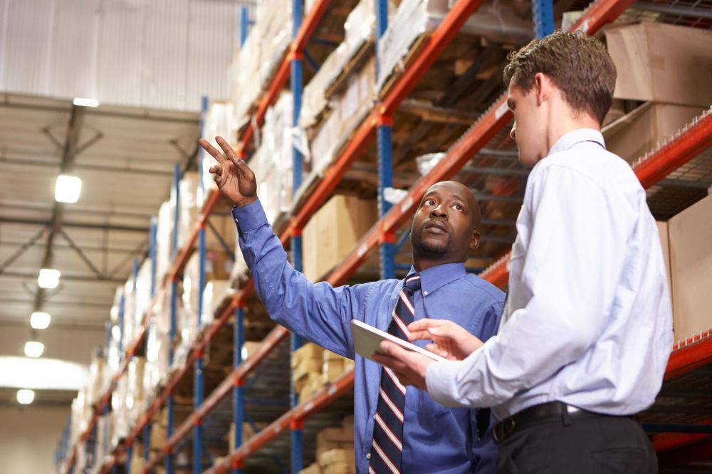 Two men standing in warehouse.