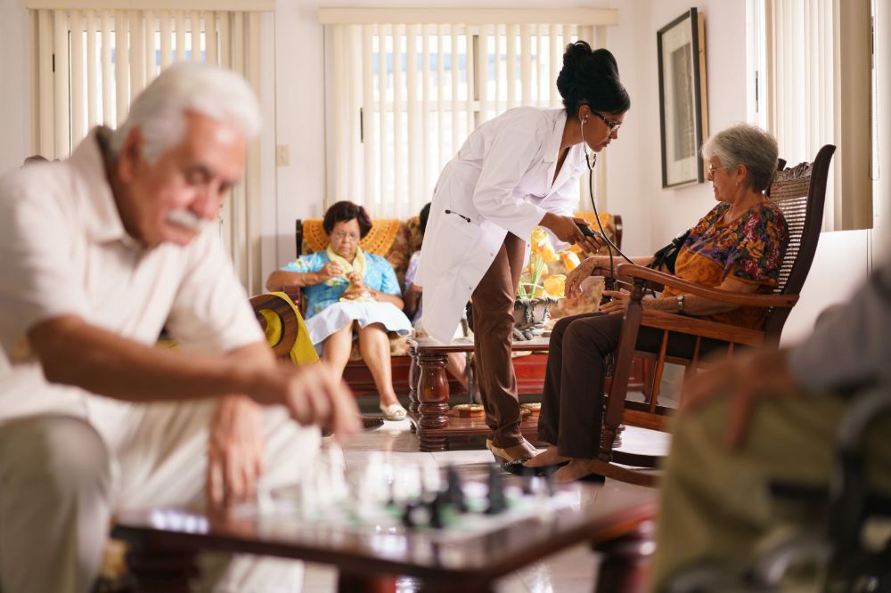 Hospice Doctor Measuring Blood Pressure To Senior Woman