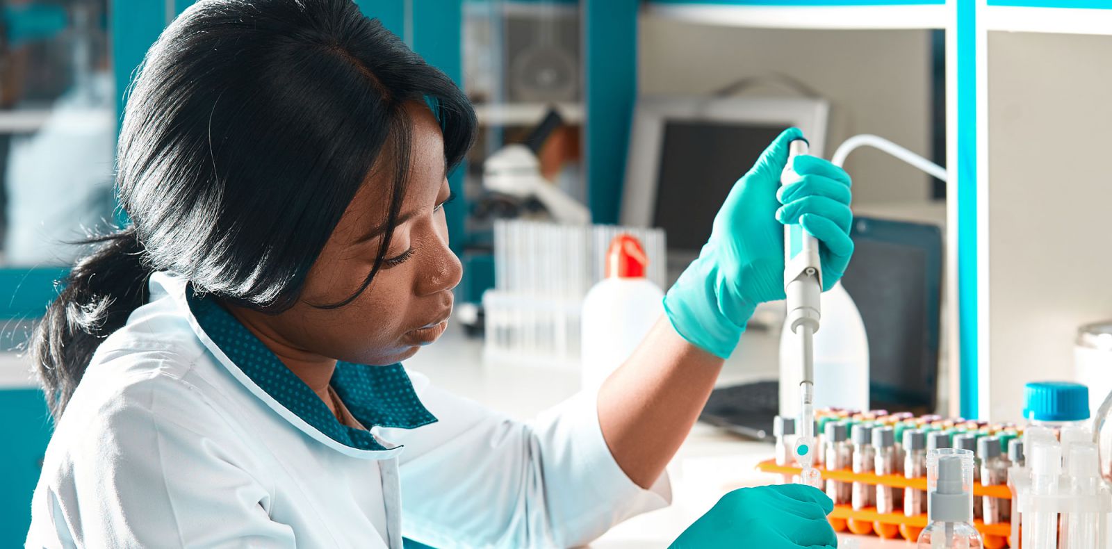 Student adding liquid to a test tube in a lab