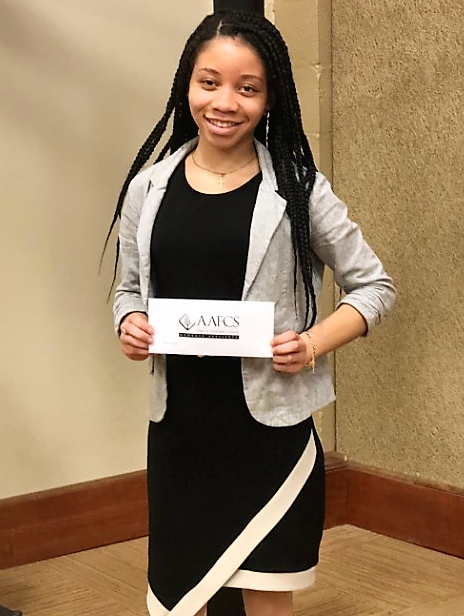 MeaLenea Homer, an FCS major, poses with the recognition of her Coveris scholarship award during the annual meeting of the GAFCS at the University of Georgia (UGA) Griffin campus.