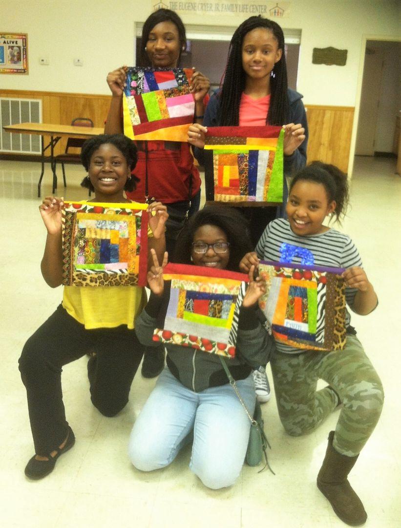 Five young ladies, part of Lillie Fowler Singleton’s youth group, pose for a photo with their quilting creations.