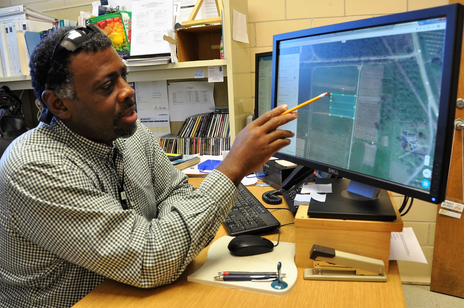 Dr. Archie Williams uses a computer program called DroneDeploy to map a plot of sorghum located on campus.