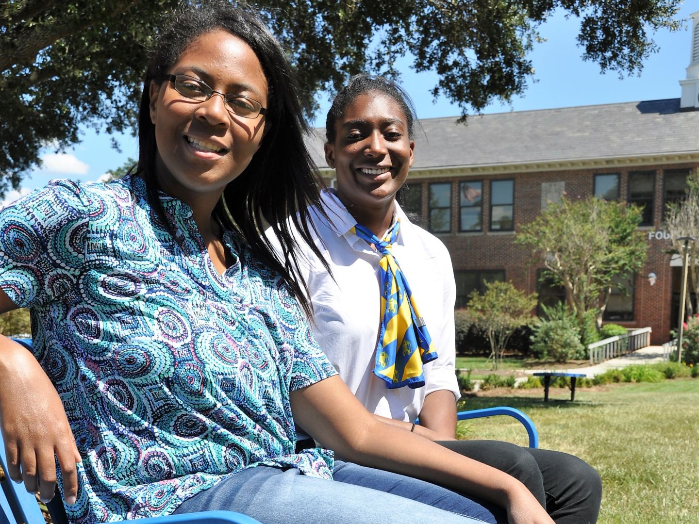 Freshmen Lindsay Corbin and Lauren Wartley (pictured from left to right) smile for the camera in front of Founder's Hall on campus.