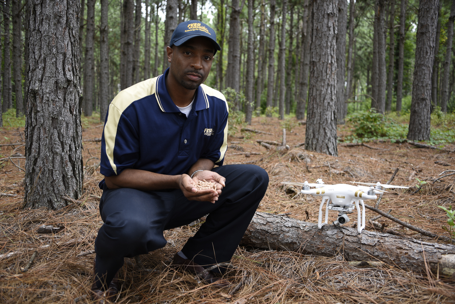 Dr. Cedric Ogden holds pellets made from pine trees at the pine research forest at Fort Valley State University.