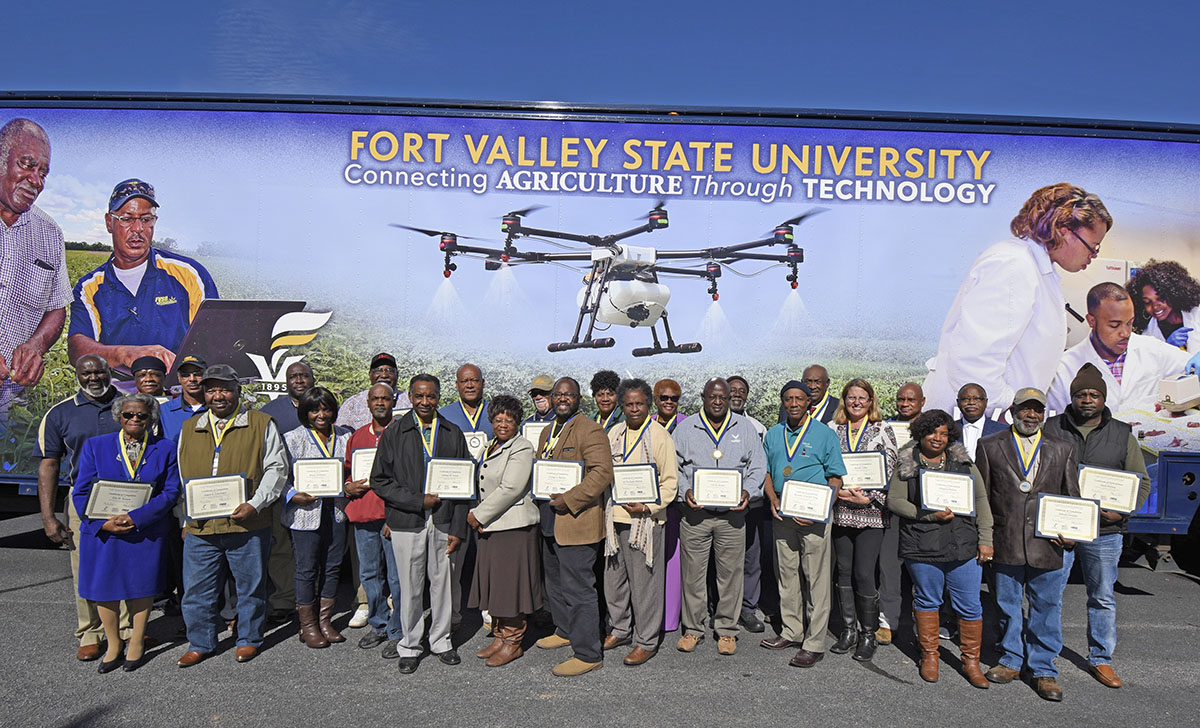 Participants in the Simplified Record-Keeping Course at the Small Farmers Training Conference and Public Listening Session in Albany, Georgia pose with their certificates in front of the FVSU Mobile Information Technology Center.