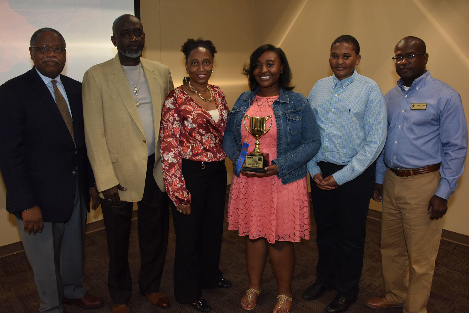 Dr. Mark Latimore Jr. (far left), FVSU Extension administrator and Phillip Petway (far right), FVSU 4-H Twiggs County Extension agent, present Cheniya Parks (holding trophy) and her family the 4-H Family of the Year Award.