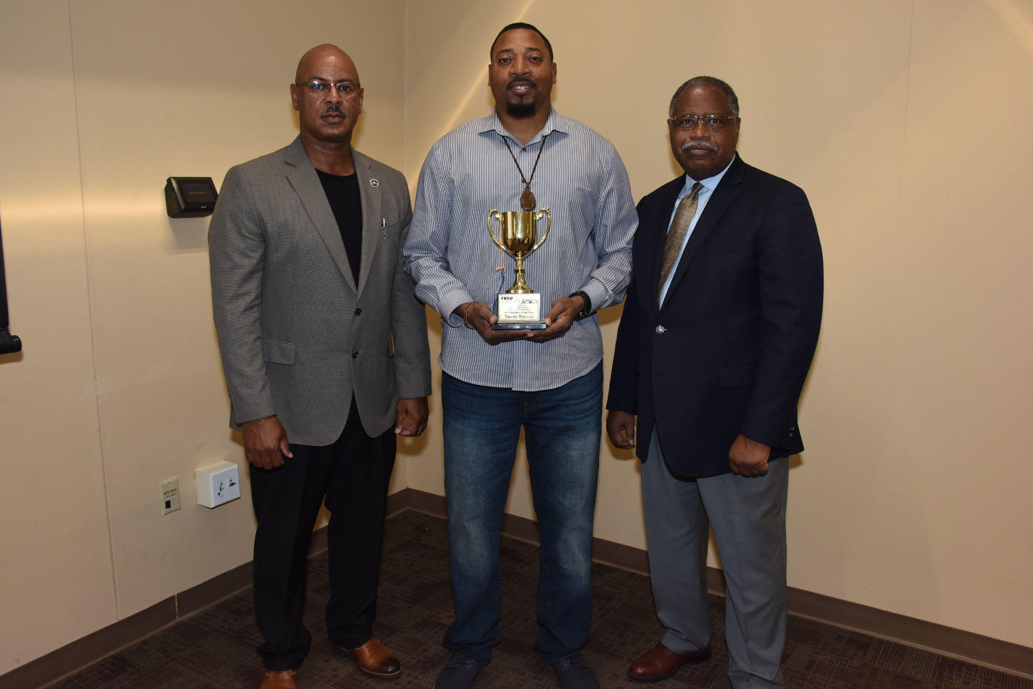 FVSU Dougherty County Extension agent Charlie Grace (Left) and Dr. Mark Latimore Jr., FVSU Extension administrator (Right) stand with Timothy Robinson (center) as he shows off his 2018 Fort Valley State University Farm Family of the Year trophy during the 41st Farm, Home and Ministers Conference.