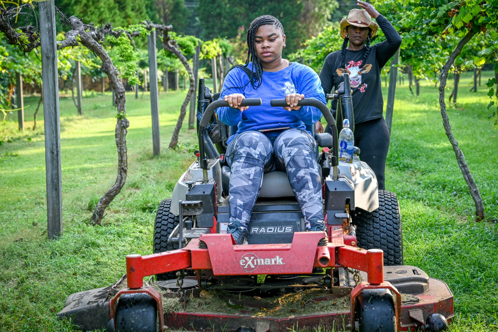 Fort Valley State University senior Kyra Holmes steers a zero-turn mower, while Crawford County, Georgia, farmer Darlene Williams Roberts instructs her.