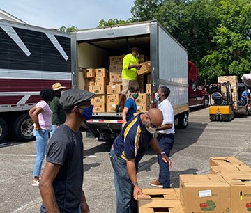 Fort Valley State University Extension personel and local voulunteers unload boxes of fresh produce and milk for residents of Americus to pick up in their vehicles. The food giveaway is part of the U.S. Department of Agriculture’s (USDA) Farmers to Families Food Box program coordinated by Fort Valley State University’s Cooperative Extension Program on June 3.