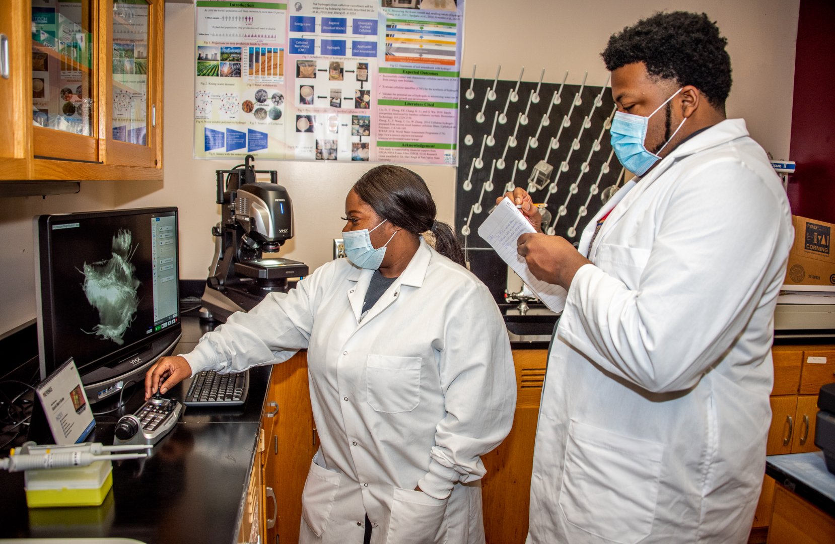 Fort Valley State University biotechnology graduate students Arlese Owens and Jacquez Smith operate an advanced digital microscope for nanotechnology research.