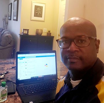 FVSU Twiggs County 4-H Extension agent, Phillip Petway, sits in front of his laptop, which he uses to provide programs to youth in his service area.