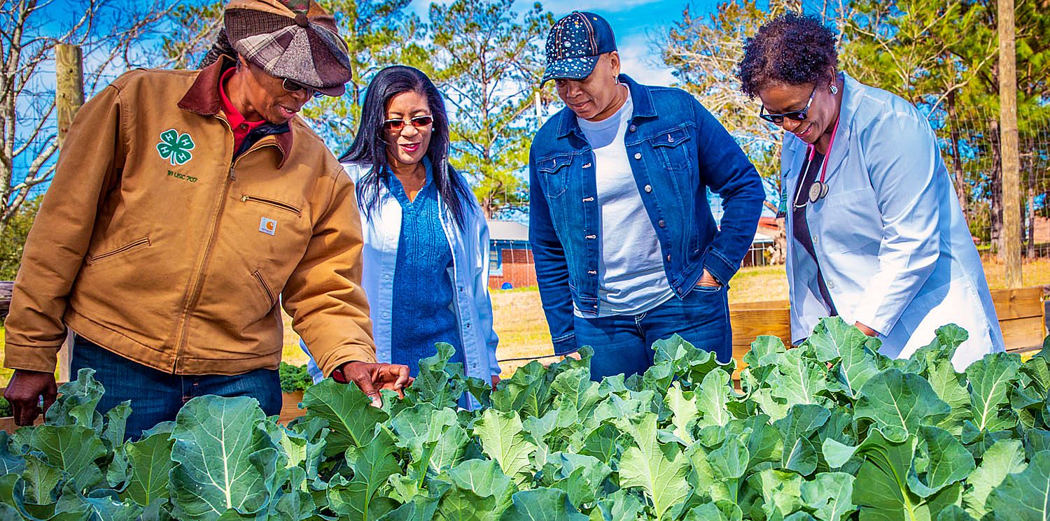 (From Left) Sam X, project coordinator of the Village Community Garden, along with Sylvester residents Faye Allen, Carolyn Evans and Dr. Marilyn Carter examine produce growing in the garden.