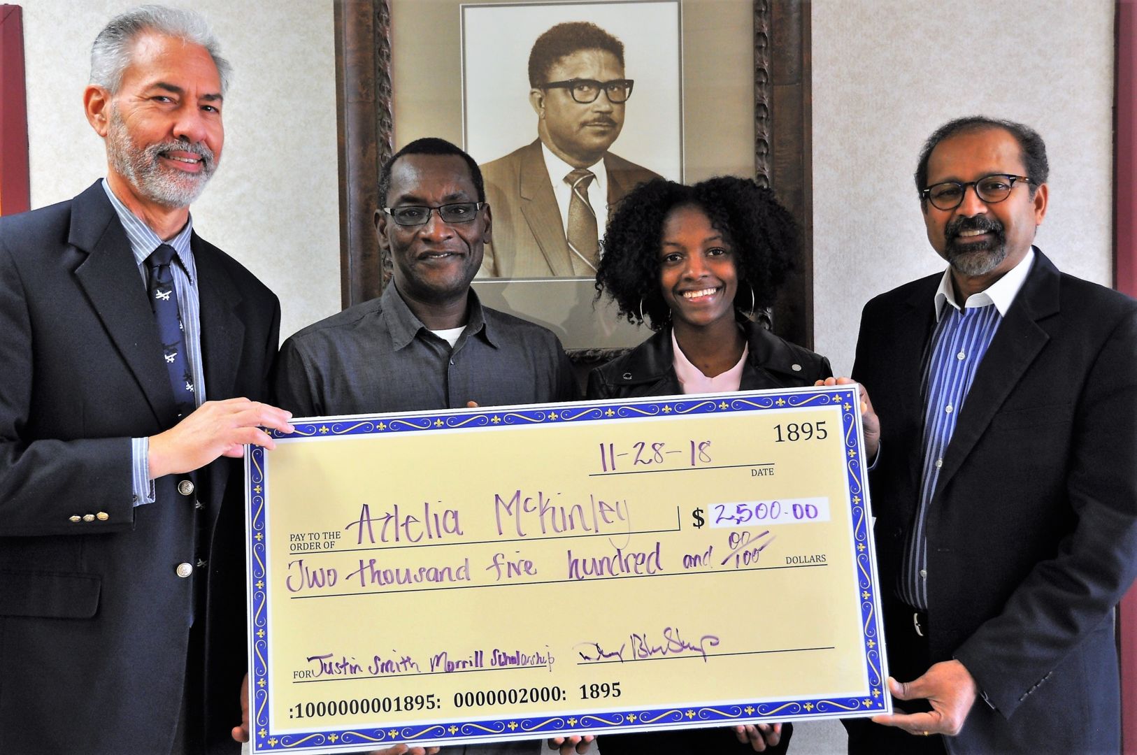 Fort Valley State University senior Adelia McKinley accepts a $2,500 Justin Smith Morrill Scholarship, which will help pay for college expenses. She is pictured with (from left to right) Dr. Daniel Blankenship, interim dean for the College of Agriculture, Family Sciences and Technology; Dr. Mohammed Ibrahim, coordinator and professor of the agricultural economics program; and Dr. Govind Kannan, associate dean for research.
