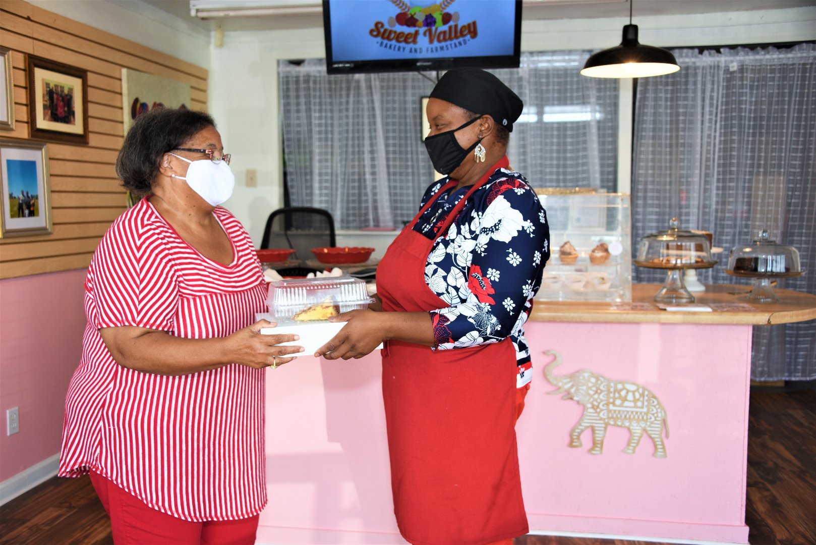 Sweet Valley Bakery and Farmstand owner Dr. Hamidah Sharif-Harris (right) serves 100 percent sugar-free treats to Fort Valley, Georgia, customer Barbara Humphrey.