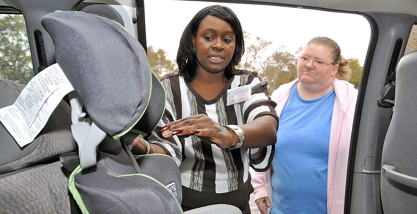 Brenda Maddox, Fort Valley State University's Marion County extension agent, shows Suzanne Kelley, how to properly secure her new car seat.