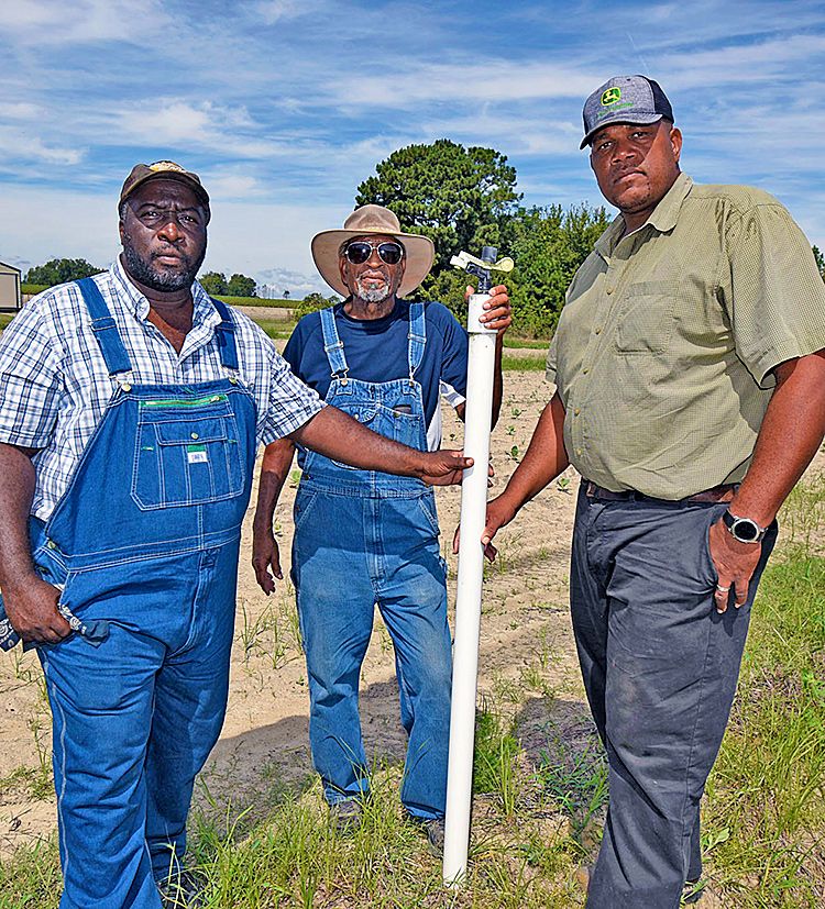 Stefan Price (left), FVSU area Extension agent, poses with Scott (far right) and his father Roland on their farm in Tattnall County.