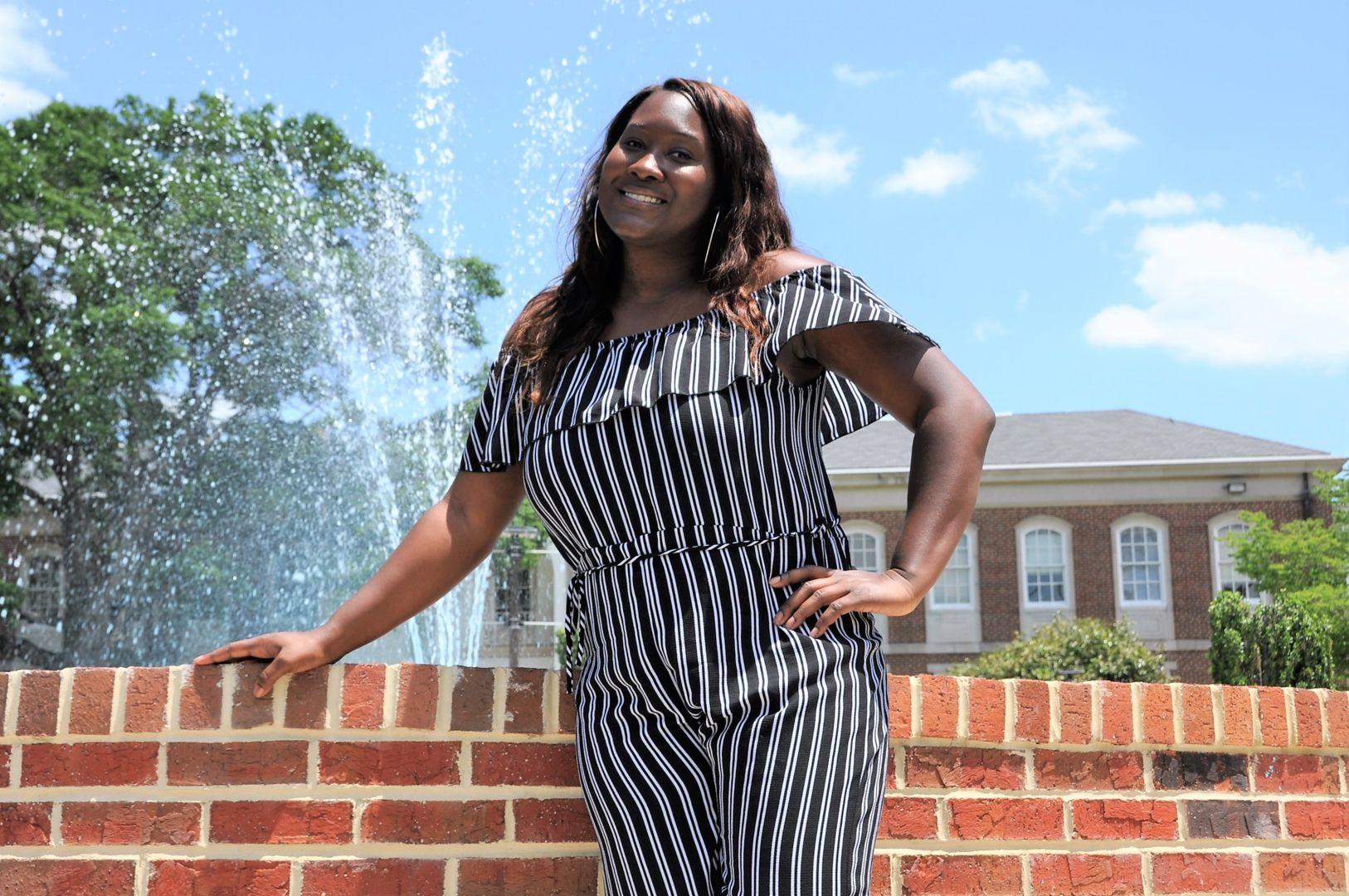Kiamata Dukes, 2018 Fort Valley State University graduate, poses in front of the fountain on campus.