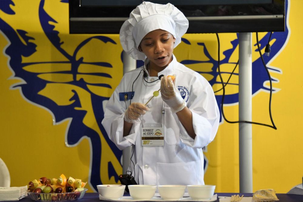 Fort Valley State University junior MeaLenea Homer demonstrates how to make rainbow fruit kabobs at the 2017 Sunbelt Agricultural Exposition in Moultrie, Georgia.