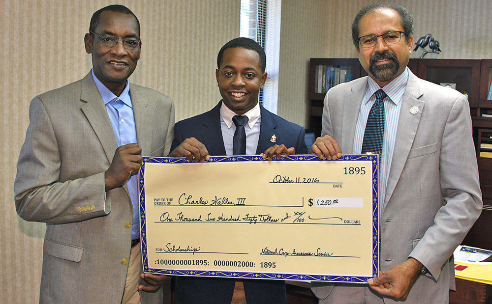Dr. Mohammed Ibrahim (far left), associate professor and coordinator of the Agricultural Economics Program at Fort Valley State University and Dr. Govind Kannan, dean of FVSU’s College of Agriculture, Family Sciences and Technology (far right), pose with Charles Waller III, an FVSU agricultural economics major and recipient of the National Crop Insurance Services Scholarship on Oct. 11.