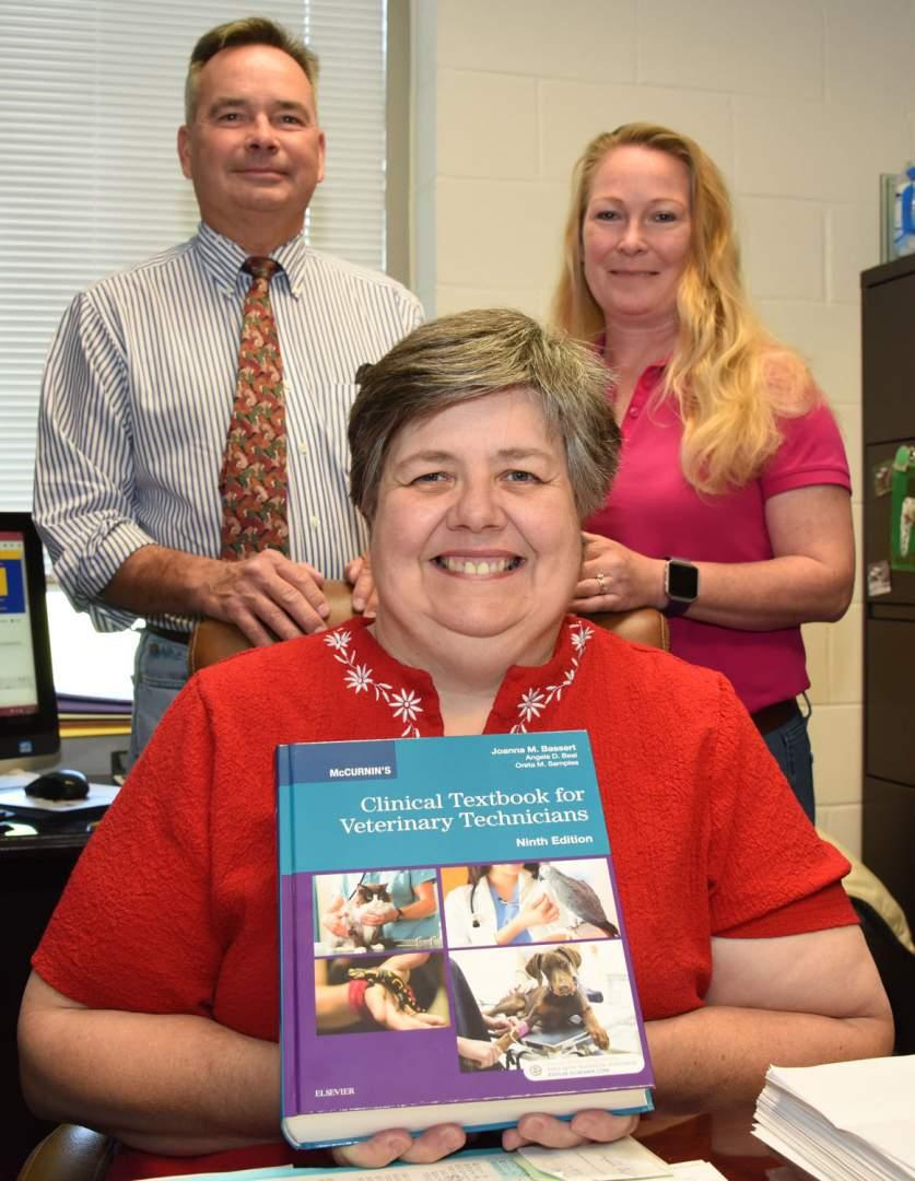 Dr. Oreta Samples (front), Dr. George McCommon (background, left) and Anna Ellis (background right) display the latest edition of the Clinical Textbook for Veterinary Technicians scheduled for use by FVSU veterinary technology students in the fall of 2017.
