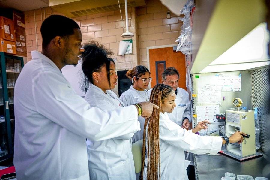 Students Jevon Clarke, Anijha Baker, J'lyscia Roberts and Latavia Powell work in the research lab with Dr. Sarwan Dhir, professor of plant biotechnology.