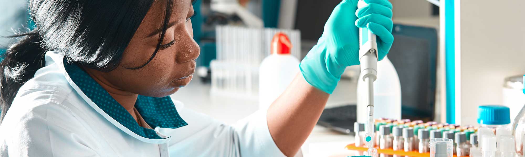 Young woman using pipette to fill test tube