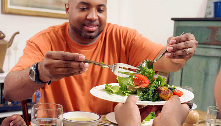 Male preparing salad plate