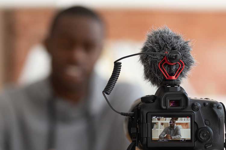 young man with DSLR camera in foreground