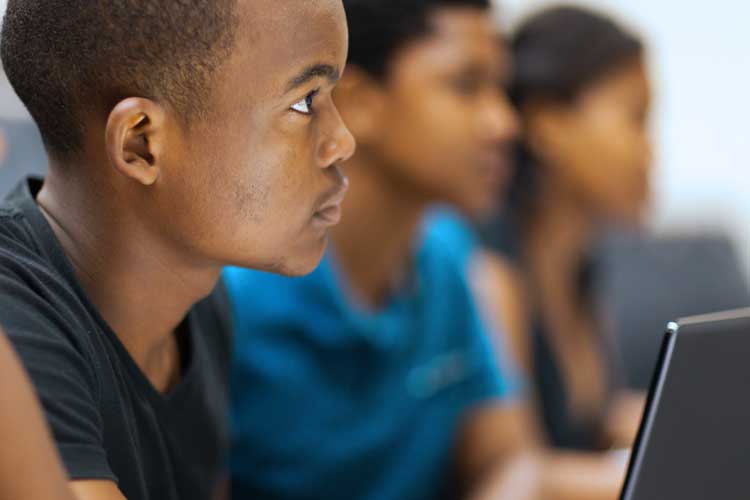 three young middle grade students in classroom