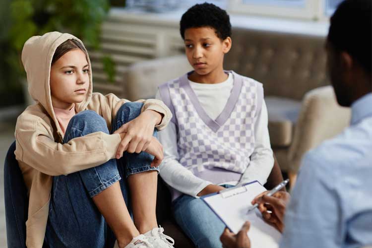 two middle school students speaking with a man