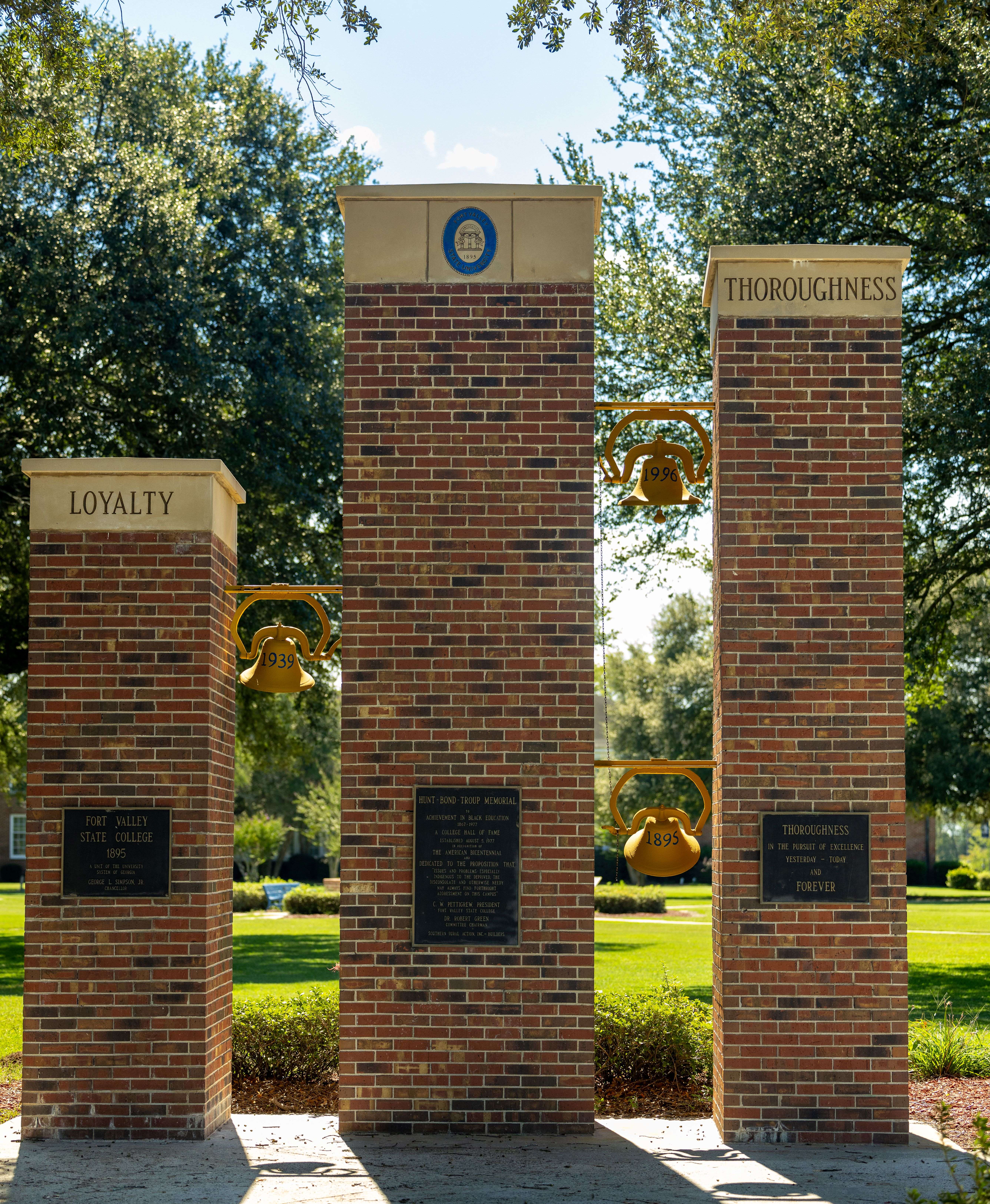 towers on campus with three bells