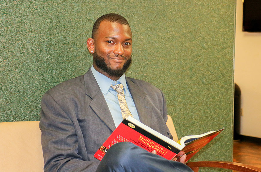 Teacher in suit reading book on couch