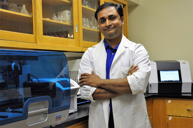 Teacher in labcoat smiling with arms crossed